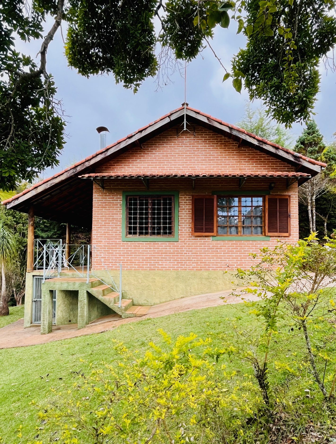 Fachada do chalé Escondidinho cercado pelo verde